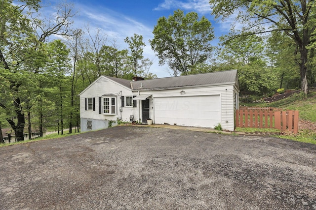 1525 Krebs Dr, Newark, OH 43055 - view of front of home with a chimney, asphalt driveway, an attached garage, and fence