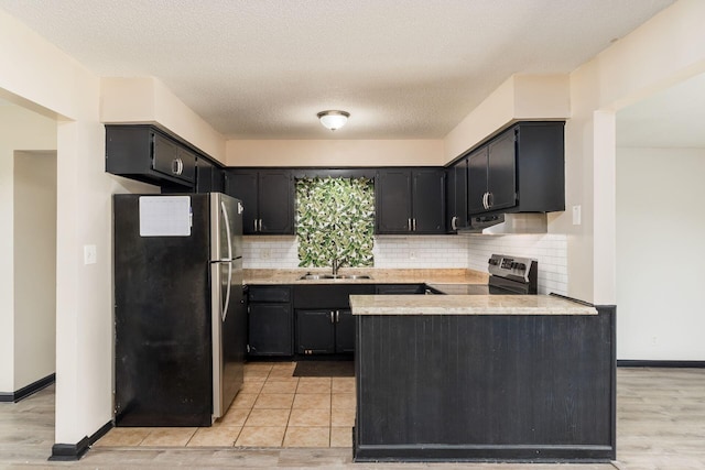 2594 Hubbell Rd, Columbus, OH 43232 - kitchen featuring appliances with stainless steel finishes, a sink, a peninsula, light countertops, and decorative backsplash