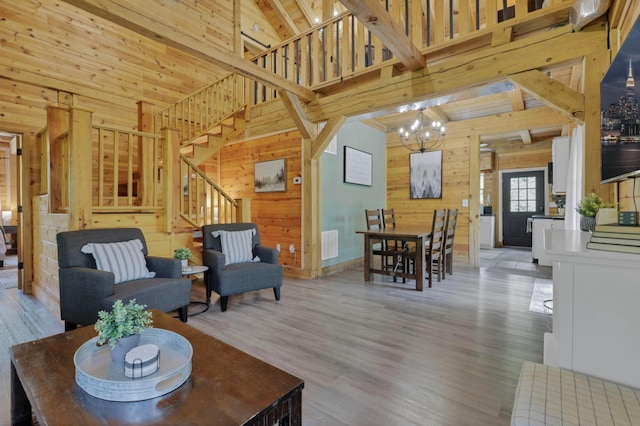 28306 Allison Rd, Mcarthur, OH 45651 - living room featuring wood walls, stairway, high vaulted ceiling, a chandelier, and wood finished floors
