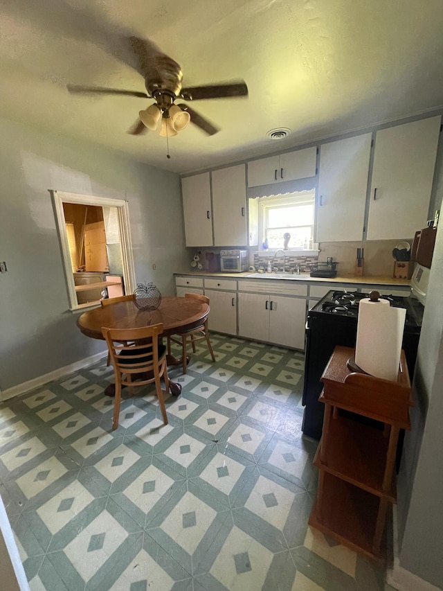 1985 Sedan Ave, Obetz, OH 43207 - kitchen with ceiling fan, white cabinetry, light countertops, a sink, and black range with gas cooktop