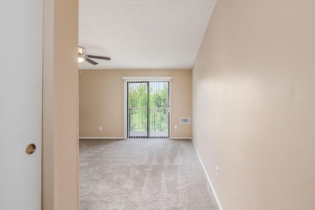 empty room with a ceiling fan, carpet floors, baseboards, and a textured ceiling