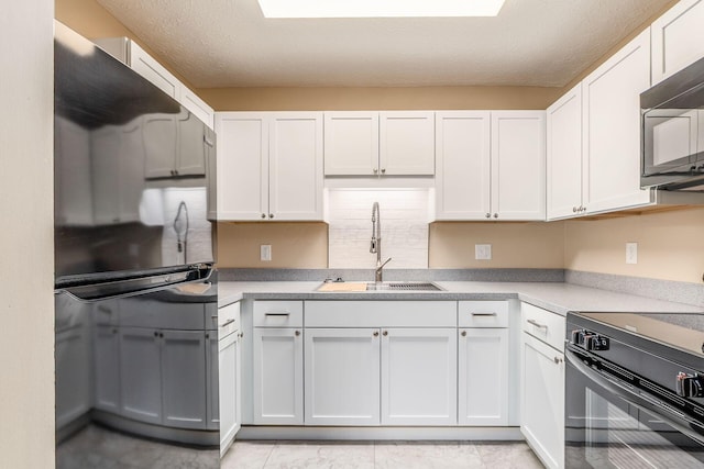 kitchen with black appliances, a sink, white cabinetry, tasteful backsplash, and a textured ceiling
