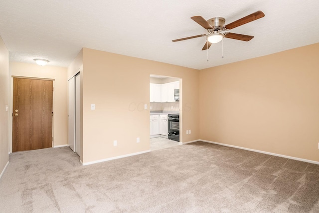 unfurnished living room with light carpet, baseboards, and a ceiling fan