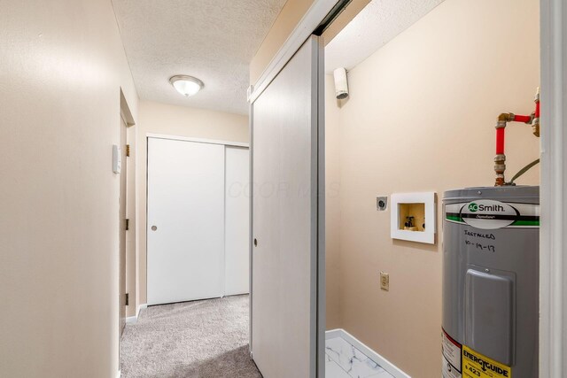 corridor featuring water heater, a textured ceiling, and baseboards