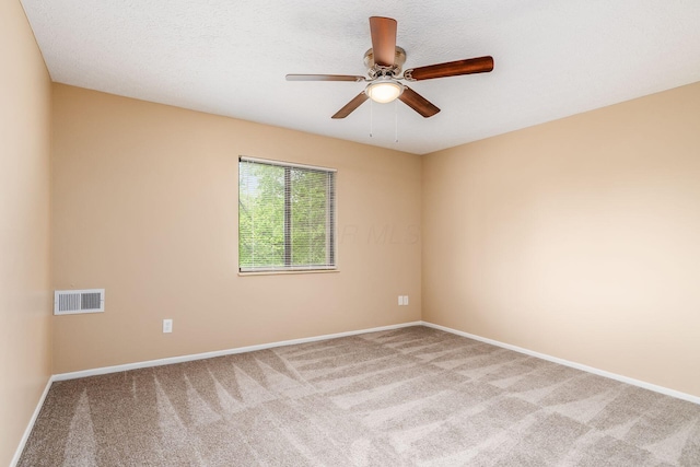 spare room featuring carpet, baseboards, and a ceiling fan