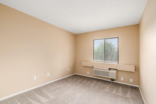 carpeted empty room featuring baseboards and a textured ceiling