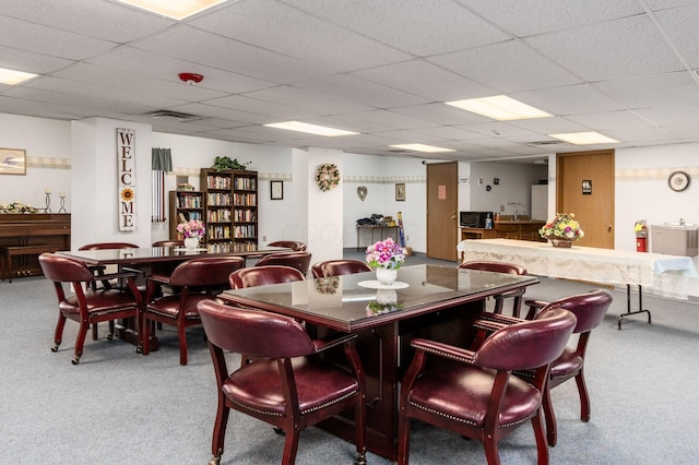 dining room featuring carpet flooring and a drop ceiling