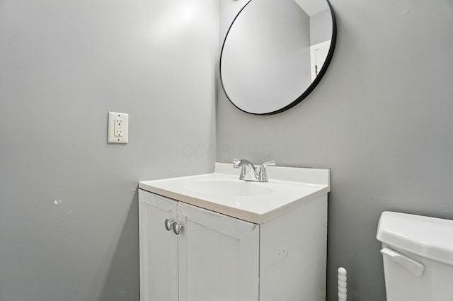 half bathroom featuring vanity and toilet
