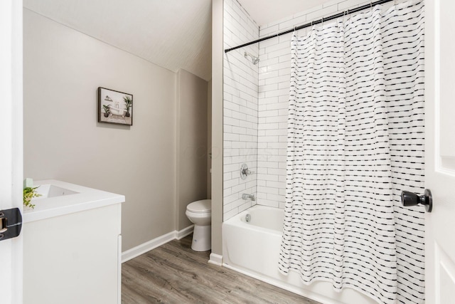 full bath with wood finished floors, toilet, shower / bath combination with curtain, vanity, and baseboards