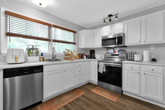 6528 Shenandoah Dr, Reynoldsburg, OH 43068 - kitchen with appliances with stainless steel finishes, a sink, dark wood-type flooring, white cabinets, and a textured ceiling