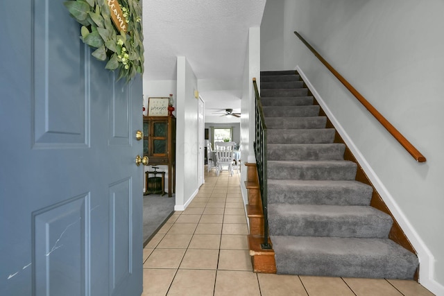 12164 Twincreek Dr, Pickerington, OH 43147 - entrance foyer featuring stairs, ceiling fan, light tile patterned floors, baseboards, and a textured ceiling