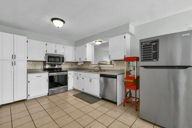 12164 Twincreek Dr, Pickerington, OH 43147 - kitchen featuring stainless steel appliances, a sink, decorative backsplash, white cabinetry, and a textured ceiling