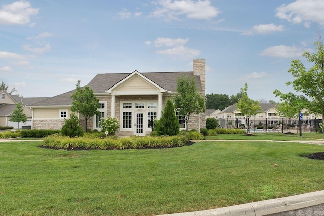 9162 Scenic View Cir, Columbus, OH 43240 - view of front of house with stone siding, a chimney, and french doors
