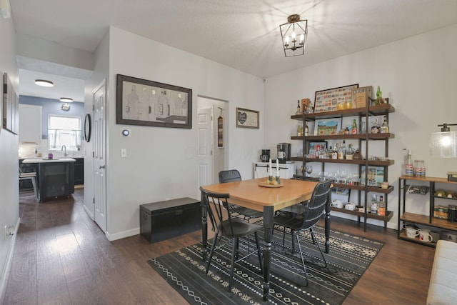 6843 John Dr, Canal Winchester, OH 43110 - dining area featuring dark wood-style floors, a chandelier, and baseboards