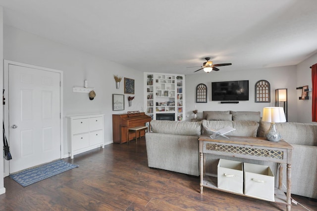 6843 John Dr, Canal Winchester, OH 43110 - living room with a ceiling fan, wood finished floors, built in shelves, a fireplace, and baseboards