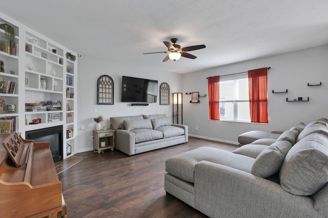 6843 John Dr, Canal Winchester, OH 43110 - living room featuring ceiling fan, dark wood-type flooring, baseboards, and a glass covered fireplace