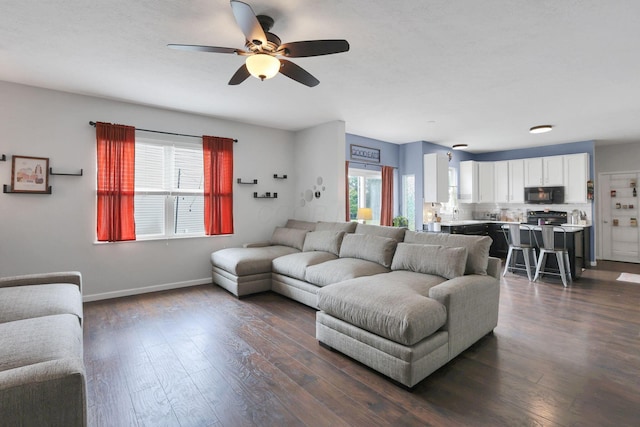 6843 John Dr, Canal Winchester, OH 43110 - living area with ceiling fan, dark wood-type flooring, and baseboards