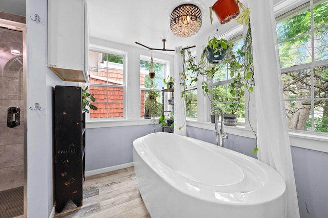 1602 Franklin Ave, Columbus, OH 43205 - bathroom featuring wood finished floors, a freestanding bath, plenty of natural light, and baseboards