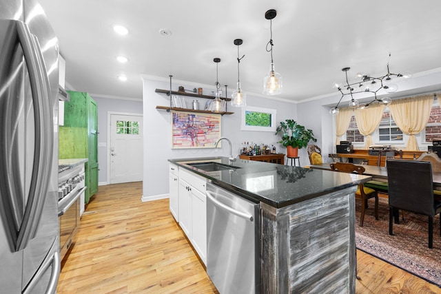1602 Franklin Ave, Columbus, OH 43205 - kitchen featuring stainless steel appliances, crown molding, a sink, an island with sink, and light wood-type flooring