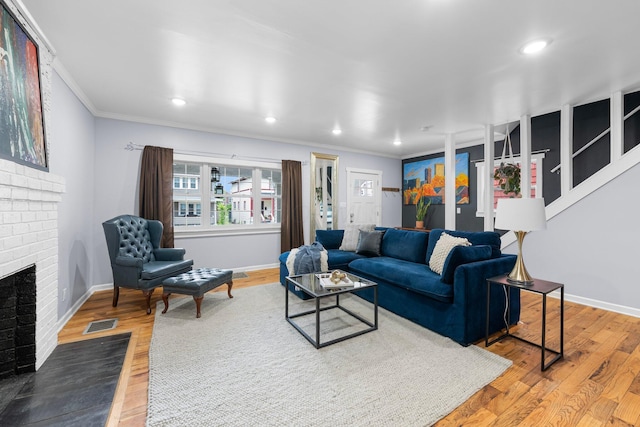 1602 Franklin Ave, Columbus, OH 43205 - living room featuring ornamental molding, a brick fireplace, baseboards, wood finished floors, and recessed lighting