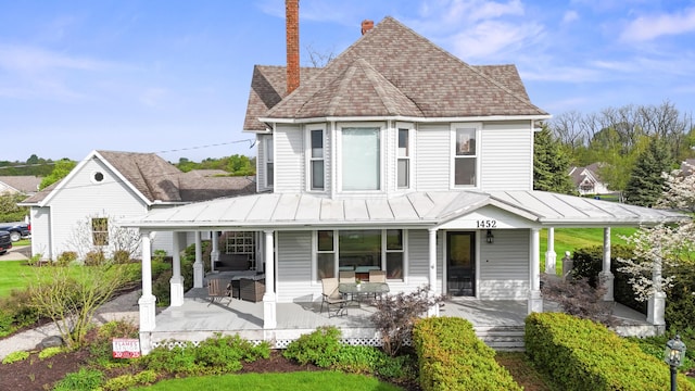 1452 W Cook Rd, Mansfield, OH 44906 - view of front of house with a porch, a chimney, roof with shingles, and a standing seam roof