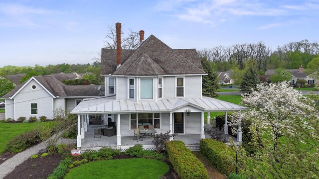 1452 W Cook Rd, Mansfield, OH 44906 - view of front of home with a porch, a standing seam roof, a shingled roof, a front lawn, and metal roof