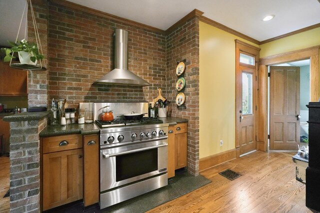 1452 W Cook Rd, Mansfield, OH 44906 - kitchen featuring high end stainless steel range, wall chimney range hood, light wood-type flooring, baseboards, and crown molding