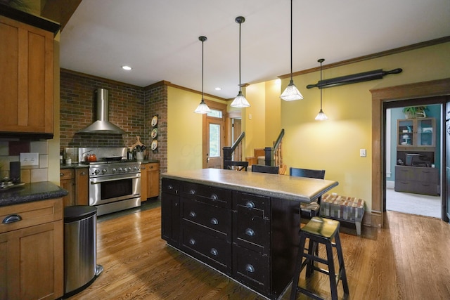 1452 W Cook Rd, Mansfield, OH 44906 - kitchen featuring stainless steel stove, wall chimney range hood, a breakfast bar area, dark wood-style floors, and decorative light fixtures