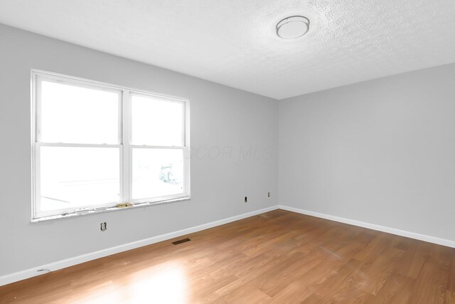 5744 Burcale Dr, Galloway, OH 43119 - empty room featuring wood finished floors, a textured ceiling, and baseboards
