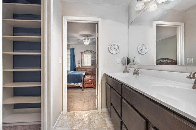 full bath with ensuite bath, double vanity, and ceiling fan