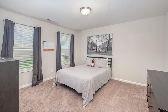 bedroom featuring light carpet, baseboards, and multiple windows