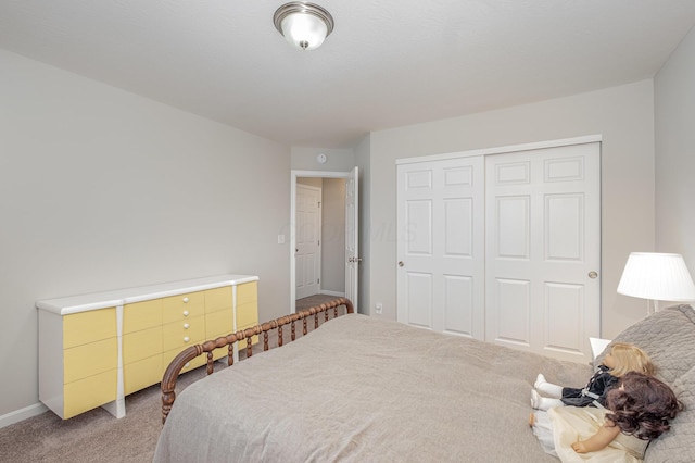 bedroom with carpet, a closet, and baseboards