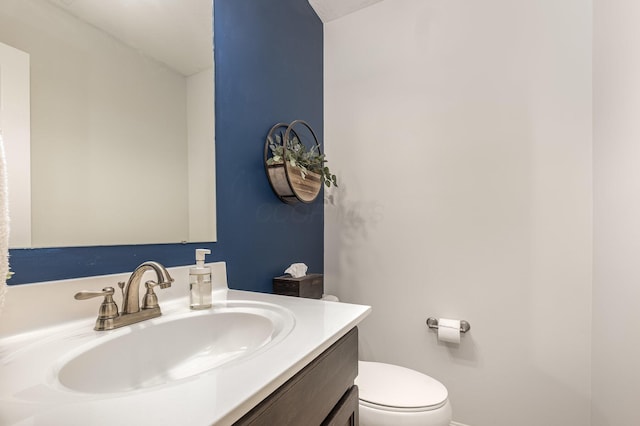 half bath featuring vanity and toilet