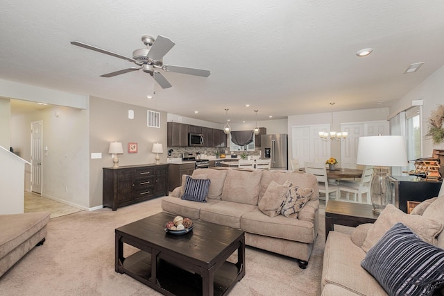 living room with a ceiling fan, a chandelier, light carpet, recessed lighting, and baseboards
