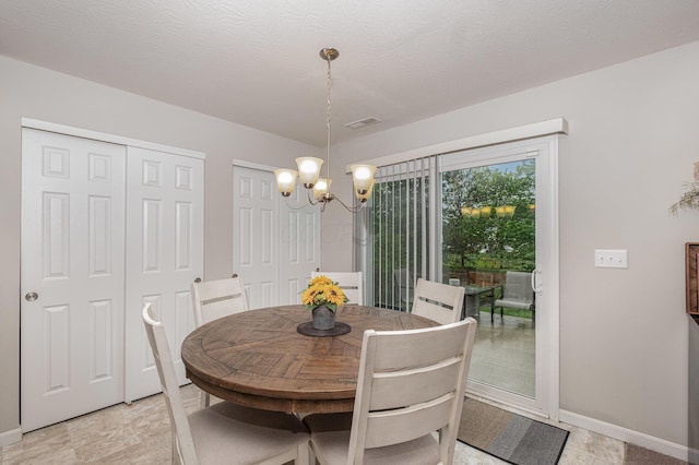 dining room with a chandelier and baseboards