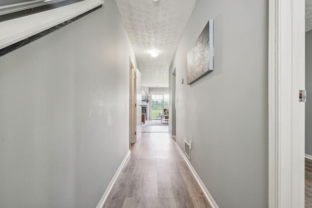 5176 Lodi Dr Unit 26B, Canal Winchester, OH 43110 - hallway featuring a textured ceiling, wood finished floors, and baseboards