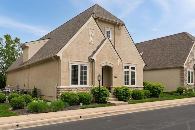 9785 Kingston Cir, Powell, OH 43065 - view of front of property featuring stucco siding, stone siding, fence, and a shingled roof
