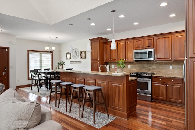 9785 Kingston Cir, Powell, OH 43065 - kitchen with appliances with stainless steel finishes, dark wood-style flooring, decorative backsplash, a kitchen breakfast bar, and recessed lighting