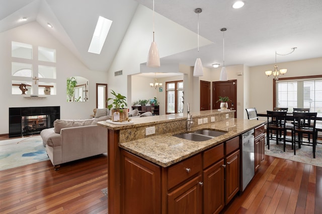 9785 Kingston Cir, Powell, OH 43065 - kitchen with a sink, a chandelier, dishwasher, a tiled fireplace, and dark wood-style floors