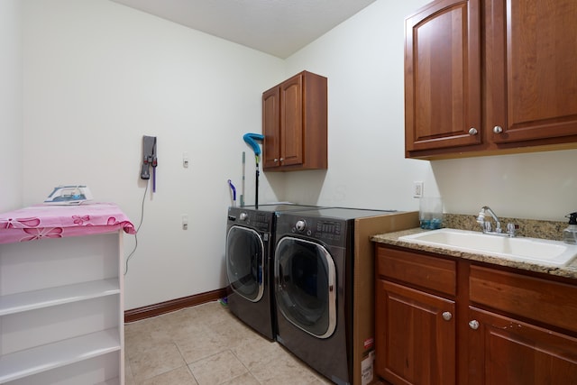 9785 Kingston Cir, Powell, OH 43065 - laundry area featuring washer and clothes dryer, cabinet space, light tile patterned floors, and baseboards