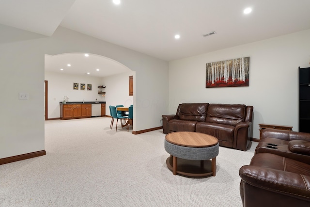 9785 Kingston Cir, Powell, OH 43065 - living room with bar with sink, baseboards, recessed lighting, light carpet, and arched walkways