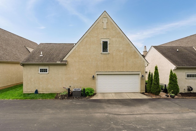 9785 Kingston Cir, Powell, OH 43065 - view of side of property with driveway, stucco siding, and a garage