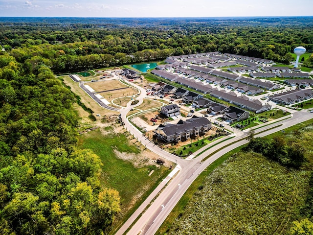 aerial overview of property's location featuring a forest and nearby suburban area
