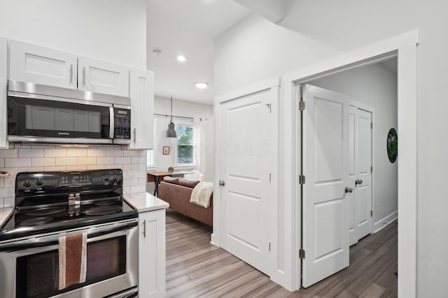 2230 N 4th St, Columbus, OH 43201 - kitchen with stainless steel appliances, light wood-style floors, white cabinetry, tasteful backsplash, and recessed lighting