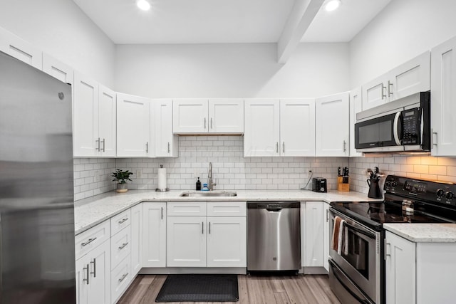 2230 N 4th St, Columbus, OH 43201 - kitchen with stainless steel appliances, a sink, light wood finished floors, white cabinets, and recessed lighting