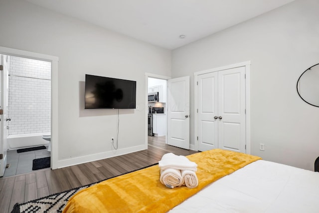 2230 N 4th St, Columbus, OH 43201 - bedroom with wood finished floors, a closet, ensuite bathroom, and baseboards