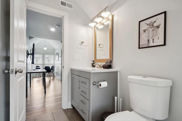 2230 N 4th St, Columbus, OH 43201 - bathroom with vaulted ceiling, toilet, vanity, tile patterned flooring, and baseboards