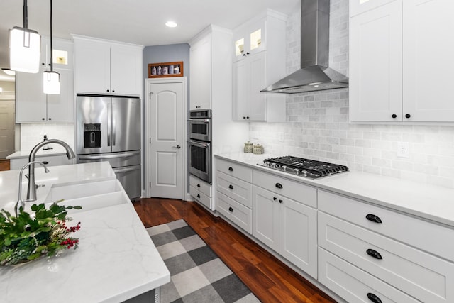 3687 Foresta Grand Dr, Powell, OH 43065 - kitchen featuring wall chimney exhaust hood, stainless steel appliances, white cabinets, pendant lighting, and dark wood finished floors