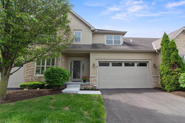 3687 Foresta Grand Dr, Powell, OH 43065 - view of front of home featuring stone siding, asphalt driveway, an attached garage, and roof with shingles
