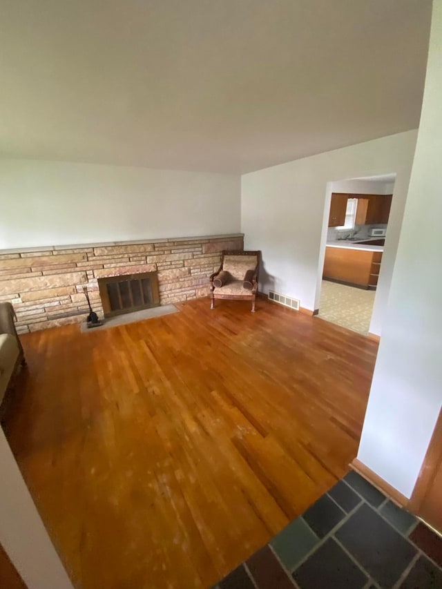 1616 Sale Rd, Columbus, OH 43224 - unfurnished living room with wood finished floors, baseboards, and a fireplace